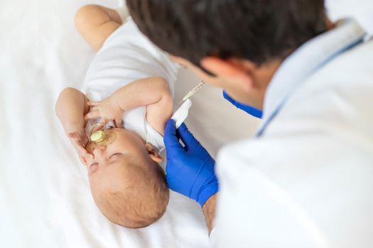 Vaccination baby, injection in the arm. Selective focus. People.