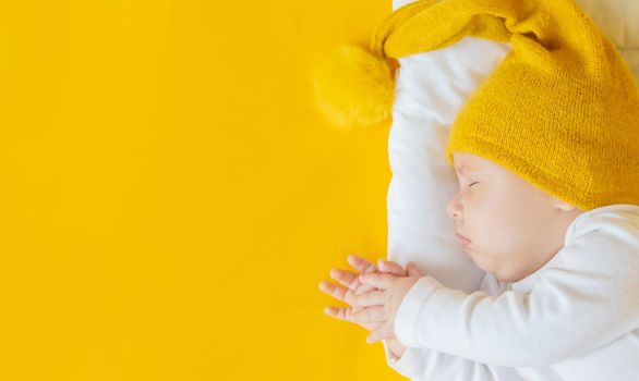 Baby sleeps on a yellow background. Selective focus. People. Merry Christmas and Happy New Year, Holidays greeting card background. Selective focus.