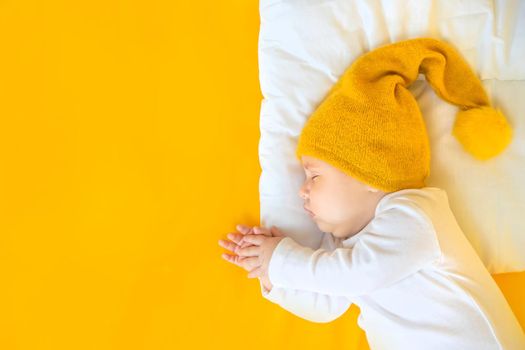 Baby sleeps on a yellow background. Selective focus. People. Merry Christmas and Happy New Year, Holidays greeting card background. Selective focus.