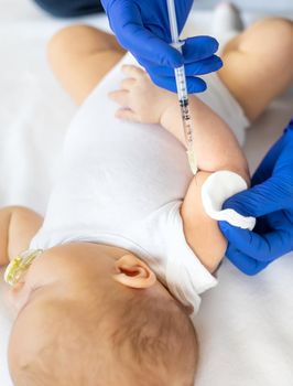 Vaccination baby, injection in the arm. Selective focus. People.