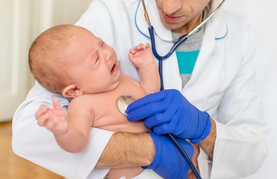 The doctor listens to the baby with a stethoscope. Selective focus. People.