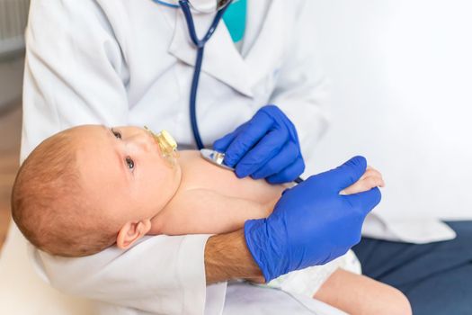 The doctor listens to the baby with a stethoscope. Selective focus. People.