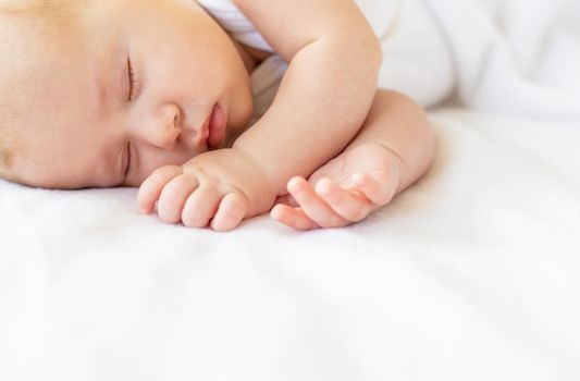 Baby sleeps against white background. Selective focus. People.