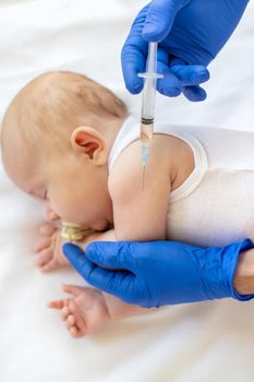 Vaccination baby, injection in the arm. Selective focus. People.