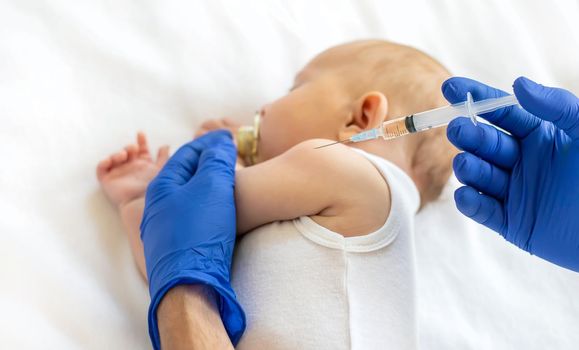 Vaccination baby, injection in the arm. Selective focus. People.