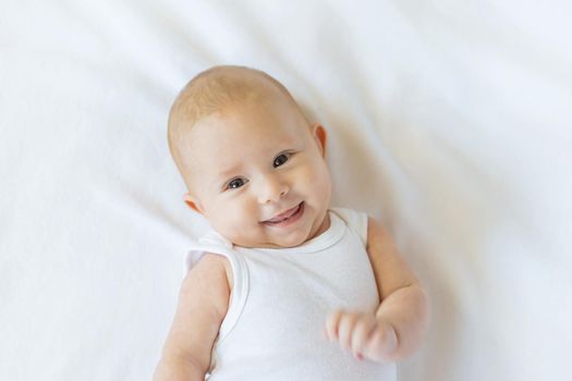 Baby smiles on a white background. Selective focus. People.
