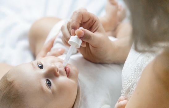 Mother gives medicine to baby for colic. Selective focus. People.
