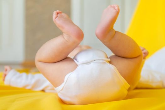 Baby feet on a yellow background. Selective focus. People. Merry Christmas and Happy New Year, Holidays greeting card background. Selective focus.