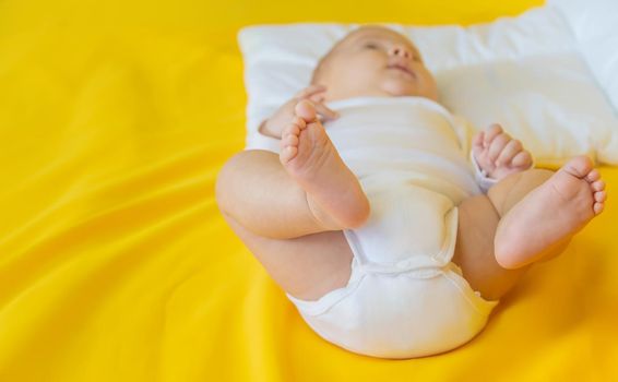 Baby feet on a yellow background. Selective focus. People. Merry Christmas and Happy New Year, Holidays greeting card background. Selective focus.