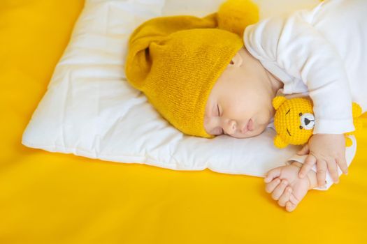 Baby sleeps on a yellow background. Selective focus. People. Merry Christmas and Happy New Year, Holidays greeting card background. Selective focus.