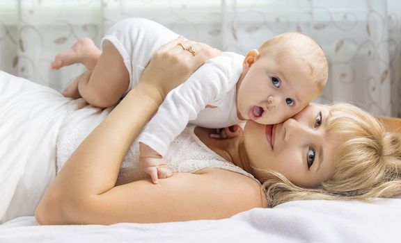 Mother with baby on a light background. Selective focus. People.