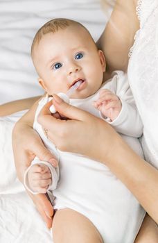 Mother gives medicine to baby for colic. Selective focus. People.