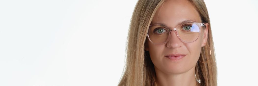 Portrait of beautiful blonde middle aged woman wearing glasses for better vision. Attractive female try on new model of frame. Ophthalmology, sight concept