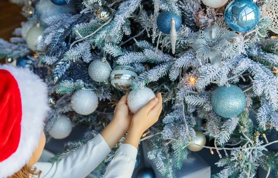 Christmas photo child decorates a Christmas tree. Selective focus. holiday.