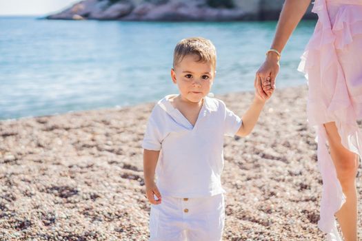 Mother and son tourists on background of beautiful view St. Stephen island, Sveti Stefan on the Budva Riviera, Budva, Montenegro. Travel to Montenegro concept.