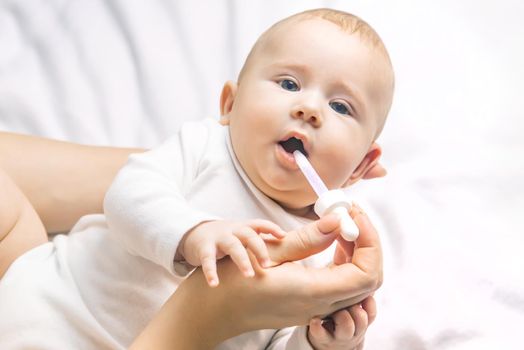 Mother gives medicine to baby for colic. Selective focus. People.