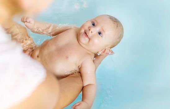 Baby after bathing in the bathroom. Selective focus. People.