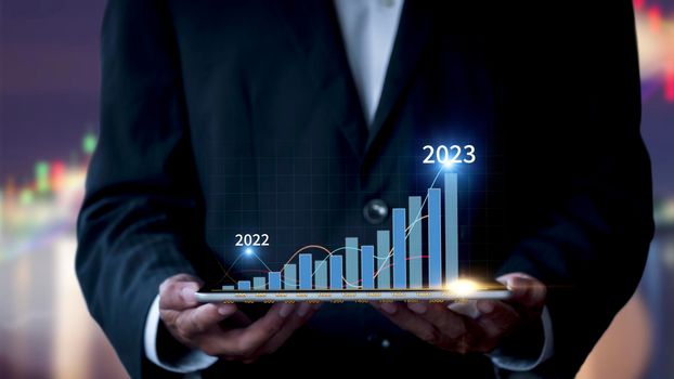 Businessman show stock market bar chart grow up to target. Business finance concept. Businessman's hands Show success graph, stocks grow every year and set goals for 2023