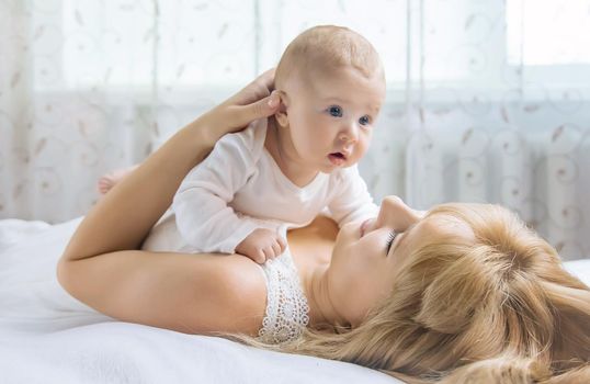 Mother with baby on a light background. Selective focus. People.