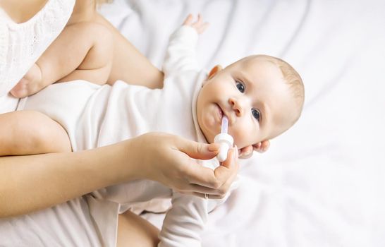 Mother gives medicine to baby for colic. Selective focus. People.