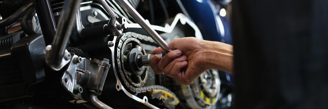 Close-up of professional mechanic repair some part of motorbike with equipment. Pit stop for any vehicle to get qualified help. Maintenance service concept