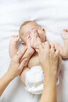 Mother massage baby on the bed. Selective focus. people.