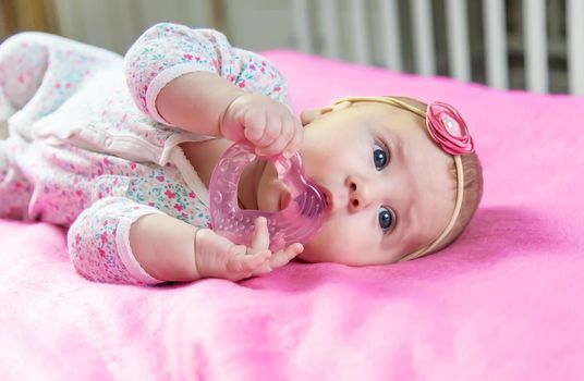 Baby is gnawing on a teether. Selective focus. people.