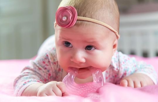 Baby is gnawing on a teether. Selective focus. people.