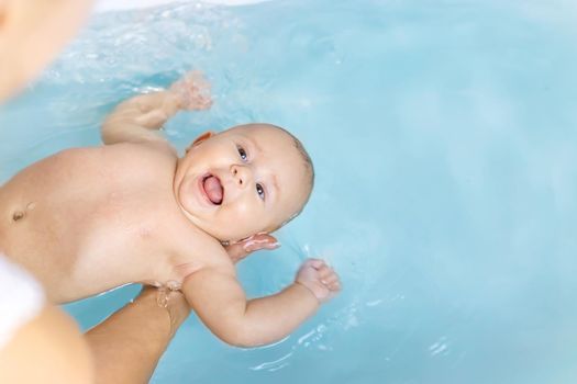 Baby after bathing in the bathroom. Selective focus. People.