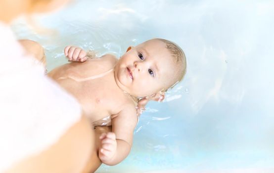 Baby after bathing in the bathroom. Selective focus. People.