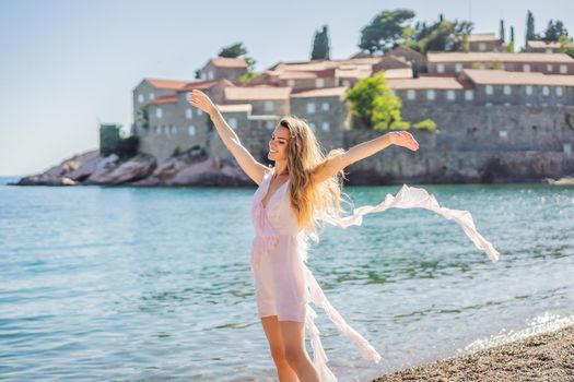 Woman tourist on background of beautiful view of the island of St. Stephen, Sveti Stefan on the Budva Riviera, Budva, Montenegro. Travel to Montenegro concept.