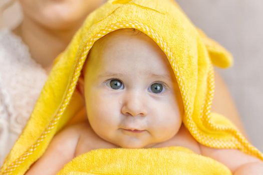 Baby after bathing in a towel. Selective focus. People.