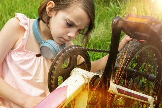 a child girl has damaged a bicycle wheel and is making repairs photo without processing. High quality photo