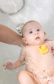 Baby after bathing in the bathroom. Selective focus. People.