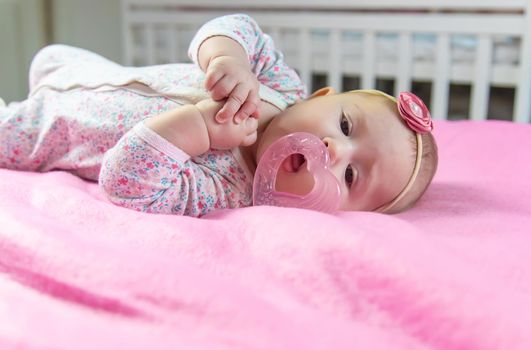 Baby is gnawing on a teether. Selective focus. people.
