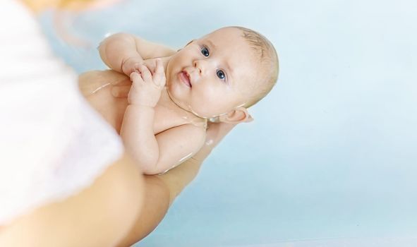Baby after bathing in the bathroom. Selective focus. People.