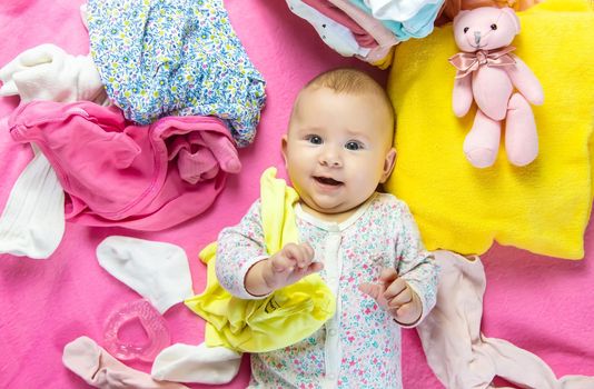 Baby scattered clothes and toys. Selective focus. people.