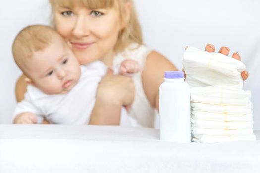 mother changes baby's diaper on a light background. Selective focus. people.