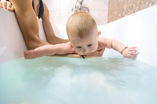 The father bathes the little baby. Selective focus. Copy space.