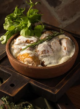 A vertical shot of a chicken covered in a creamy sauce