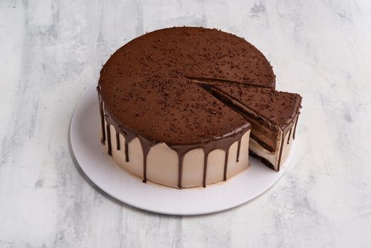 A top view shot of a chocolate cake on a white plate.