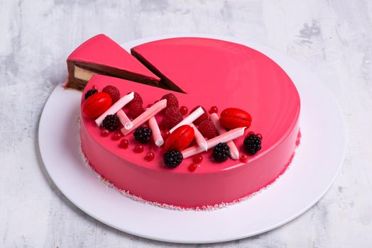 A closeup shot of a tasty cake topped with candies and fresh fruits