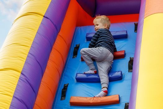 In the summer, in the amusement park, inflatable slide for kids climbs.