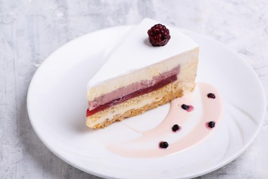 A closeup shot of white-layered cake topped with fresh berries