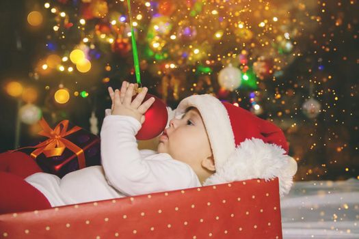 Baby is under the tree, Christmas. Selective focus. Holiday.