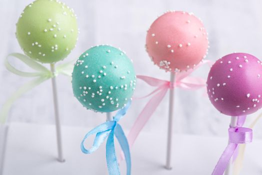 Colorful cake pops on a blurred background