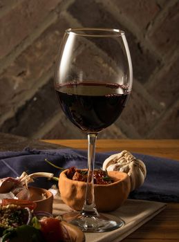 A glass of wine on a table with dishes