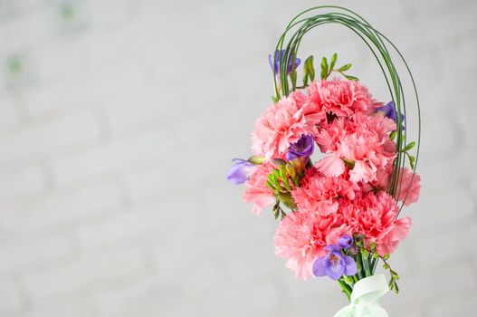 A closeup of a beautiful composition with pink spray carnations and freesia isolated on a white background