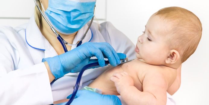 The doctor listens to the baby with a stethoscope. Selective focus. People.