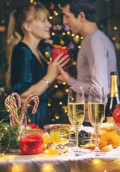 Champagne in hand against the background of the Christmas tree. People. Selective focus. Holiday.